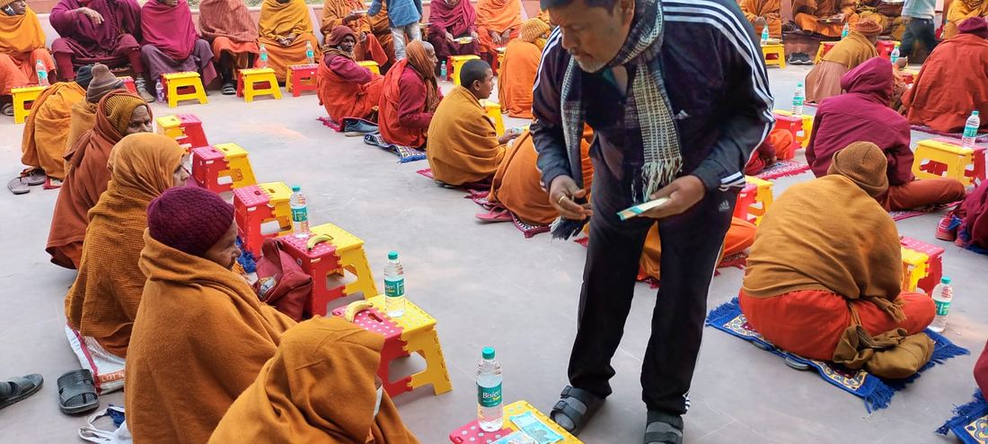 Offering dakshina to seated monks